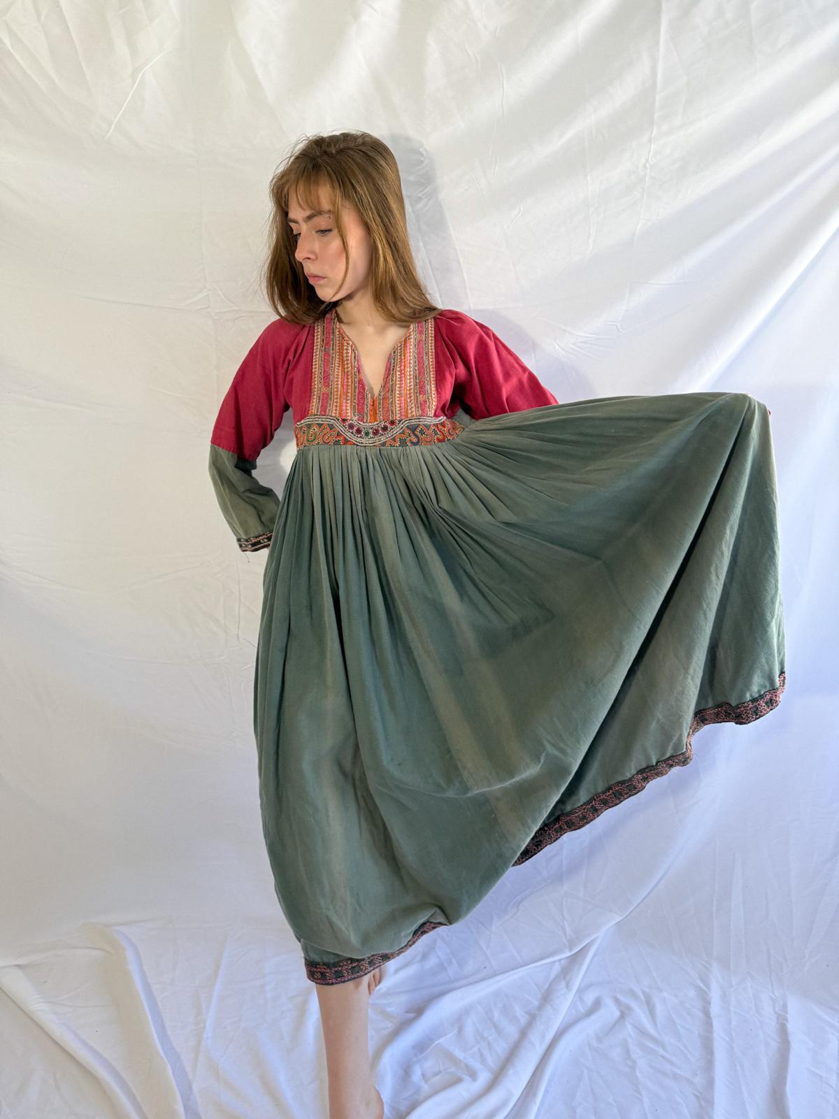 Woman wearing a long, flowing dress with afghan flowy dress a white background