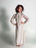 Woman wearing a 1960s Prairie Dress with Ruffles against a plain background