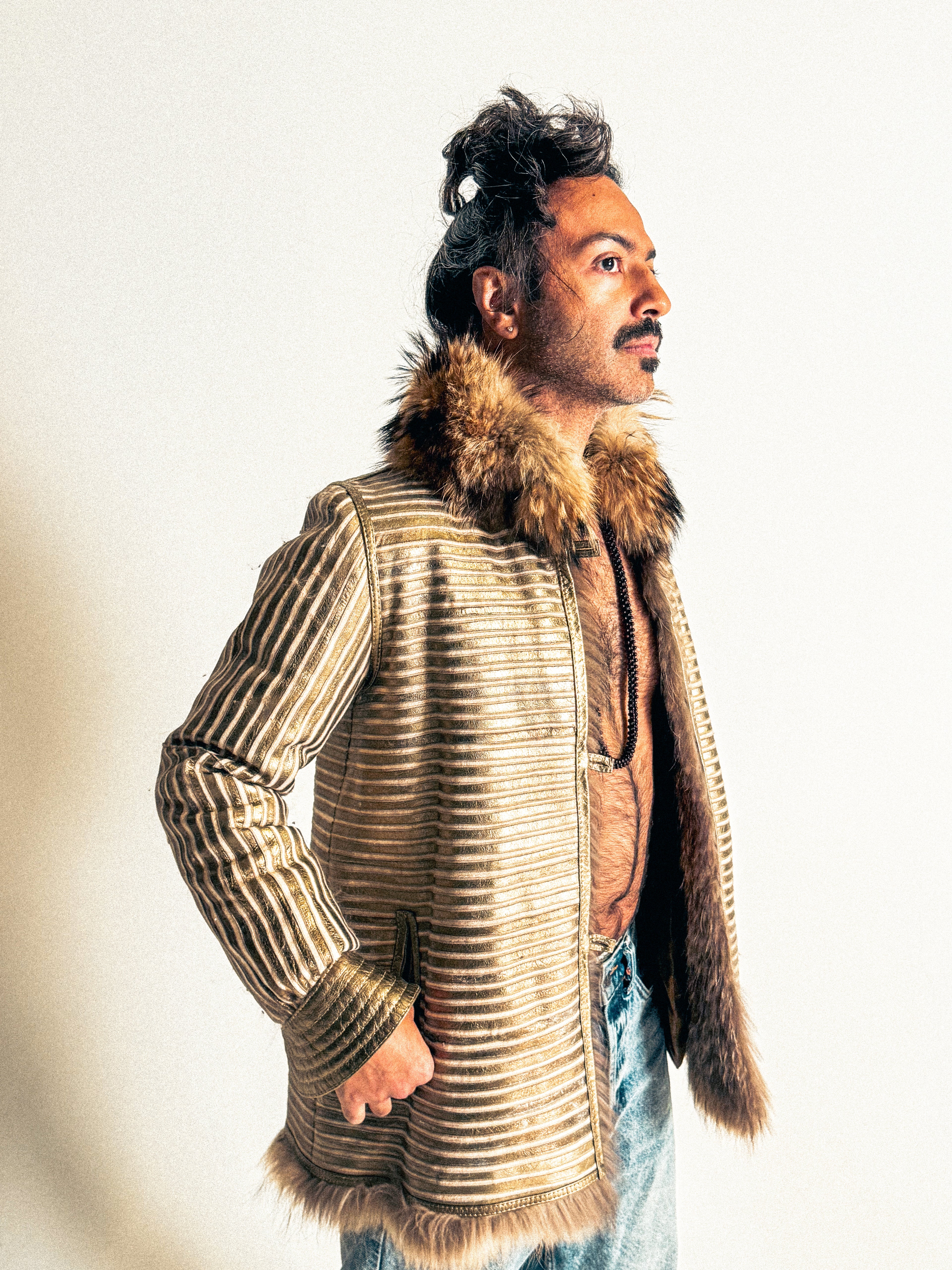 Man wearing a fur-lined jacket with a neutral background