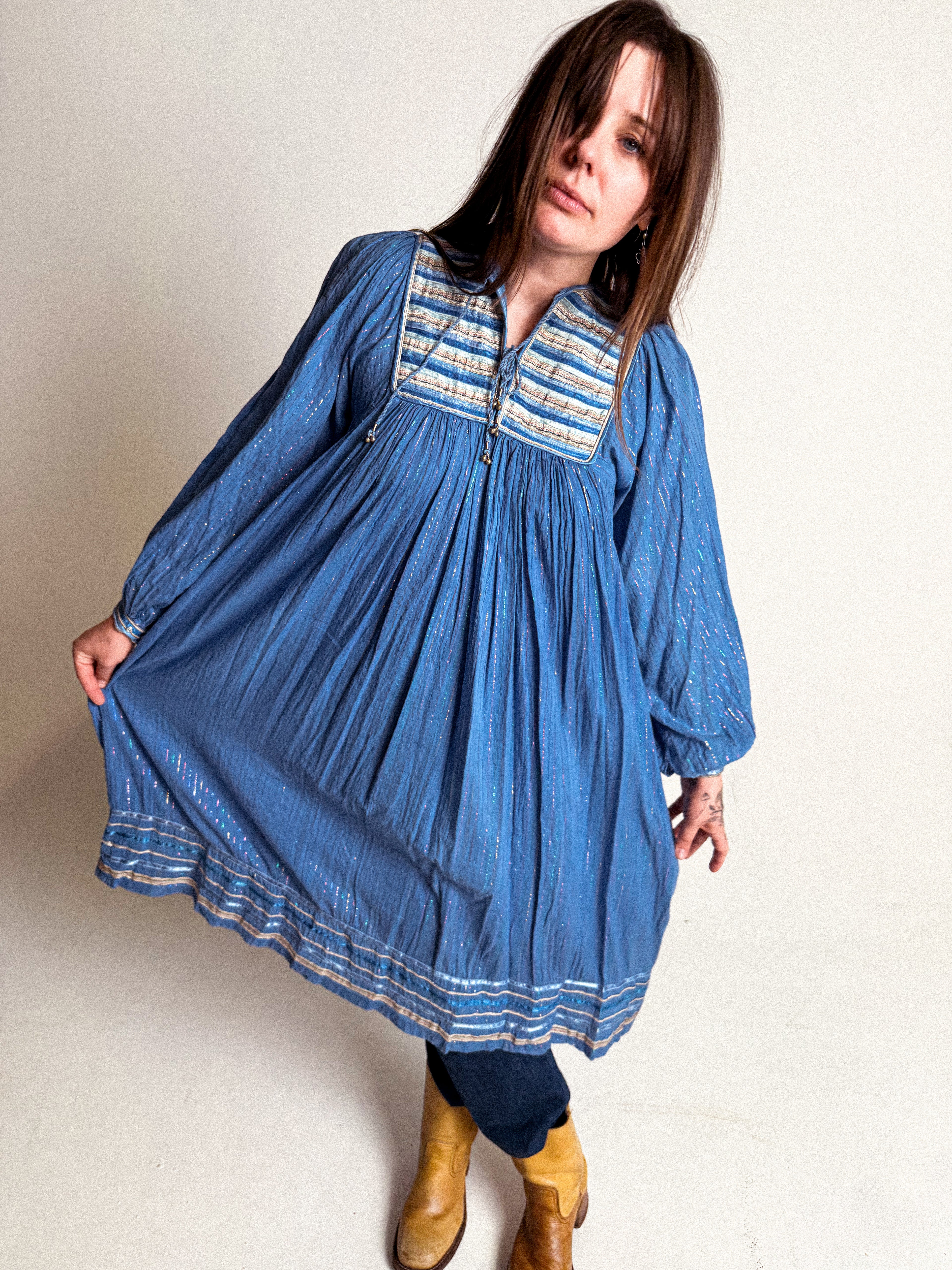 Woman wearing a blue 1970s Cotton Gauze and Lurex Dress on a plain background