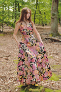 Woman in a floral dress standing in a forest