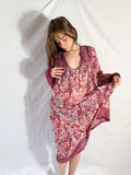 Woman wearing a red floral dress against a white background