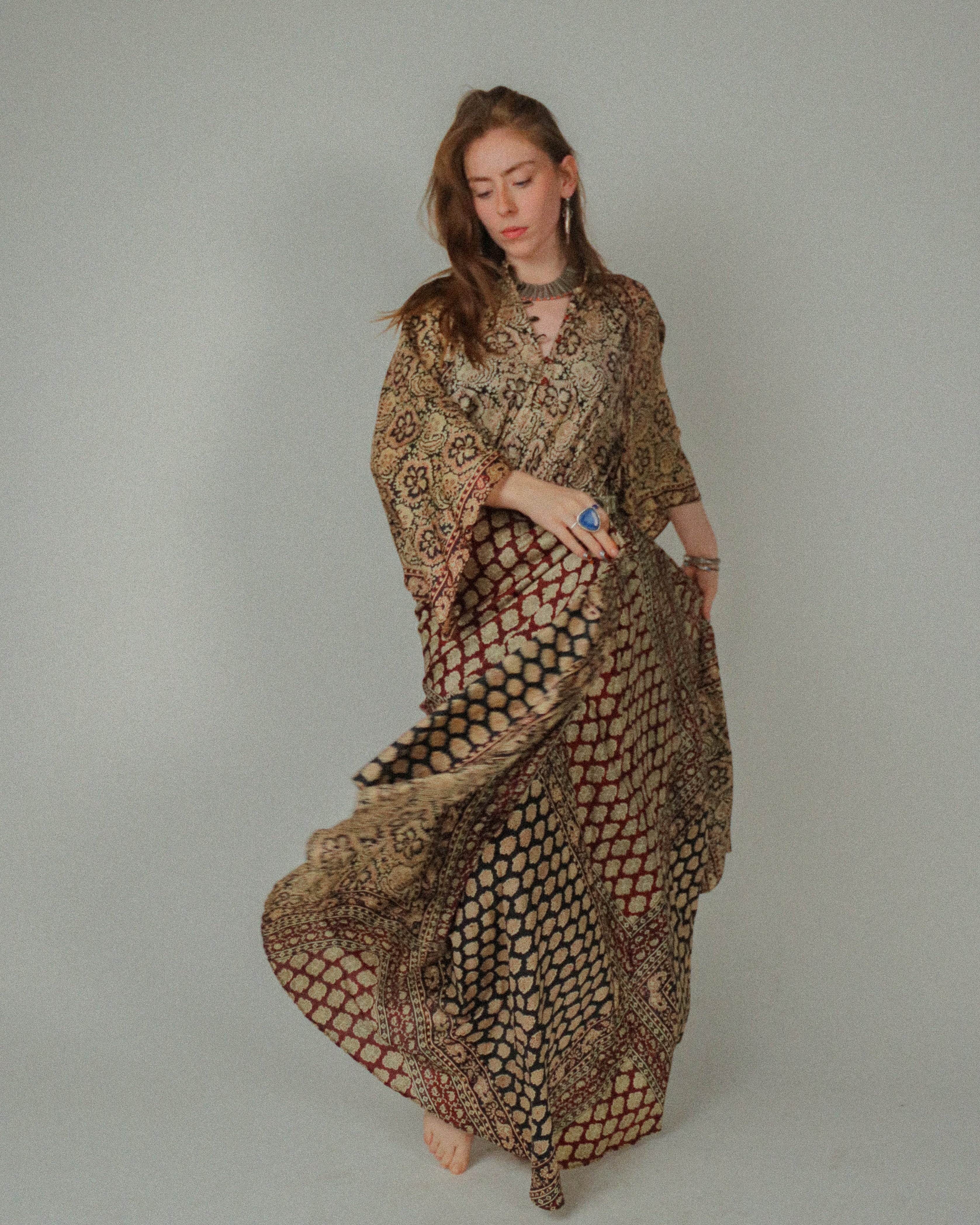 Woman wearing a patterned dress against a plain background