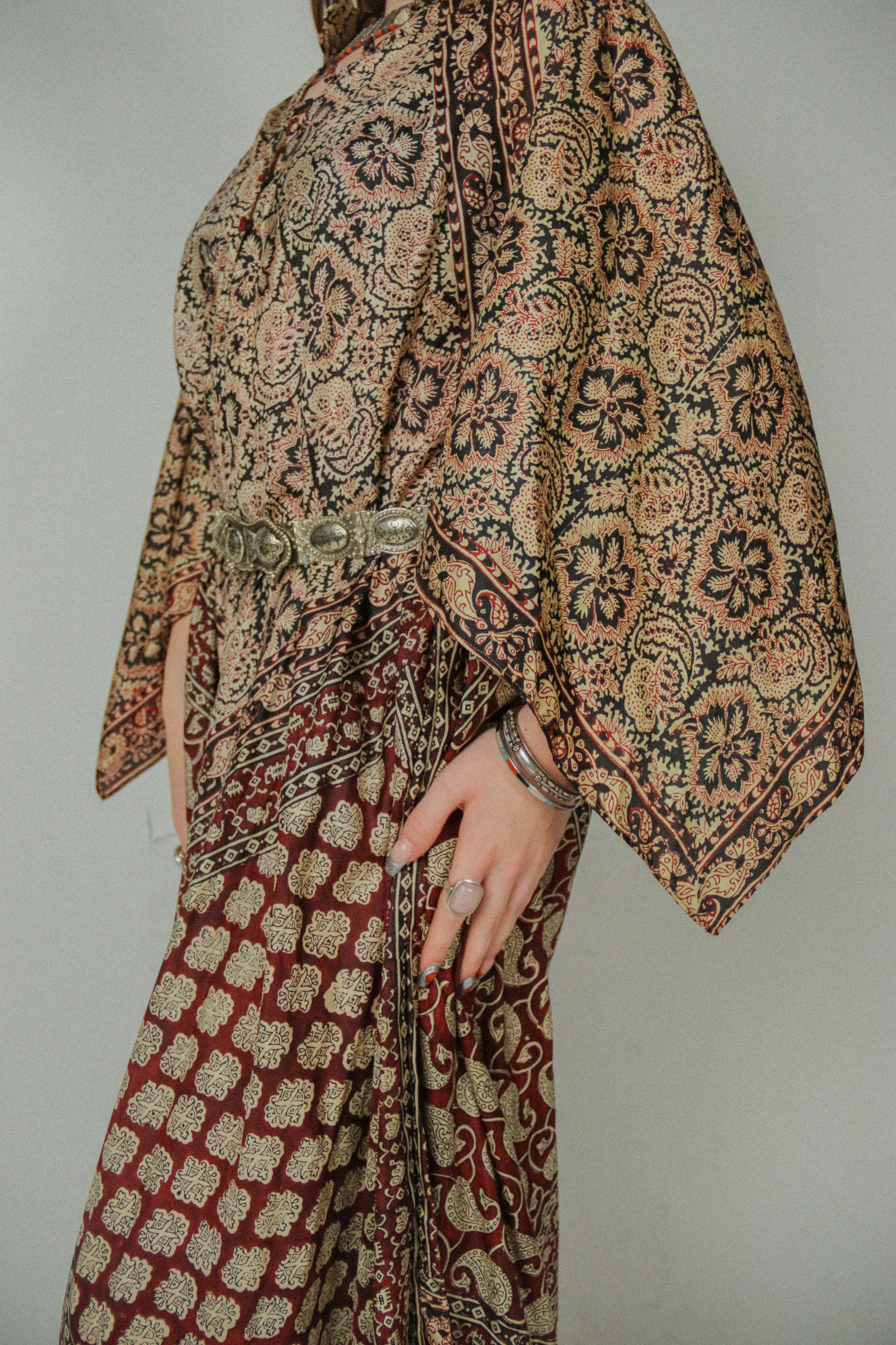 Patterned garment with a belt on a plain background