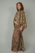 Woman wearing a patterned outfit against a plain background
