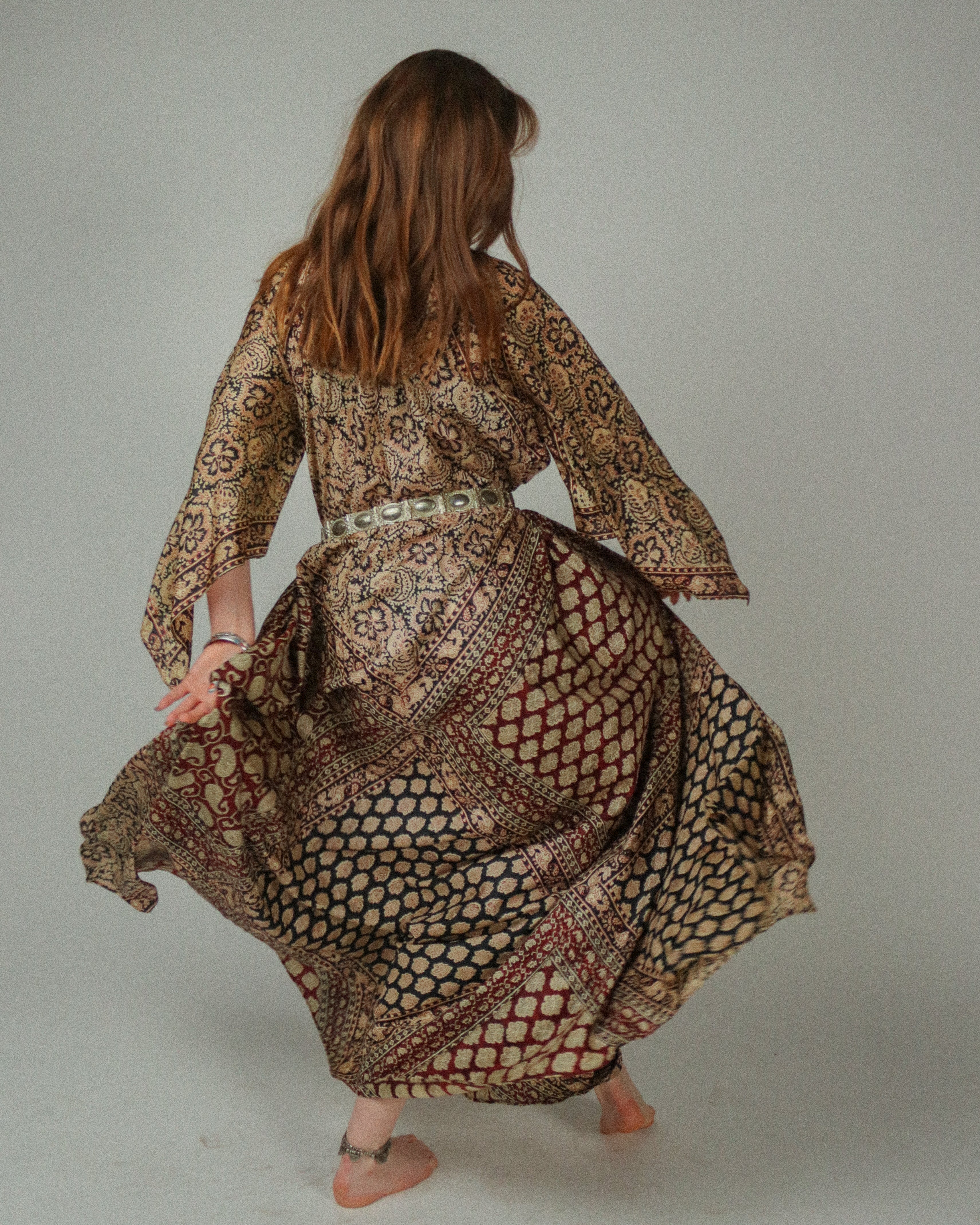 Woman wearing a patterned dress against a plain background