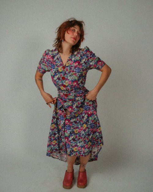 Woman wearing a 1940s Floral Maxi Teadress against a plain background